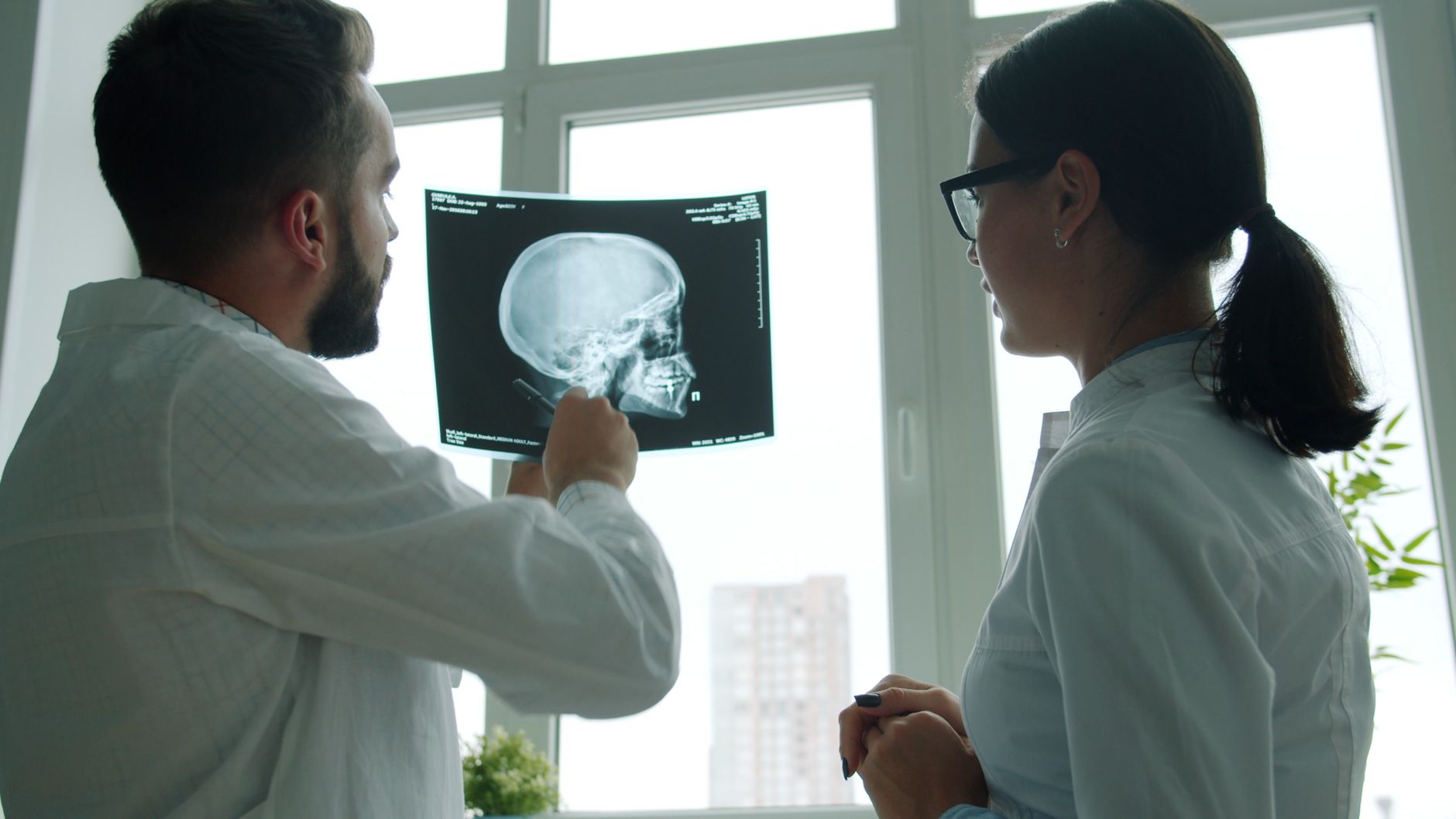 Medical professionals examining an X-ray film in a hospital setting.