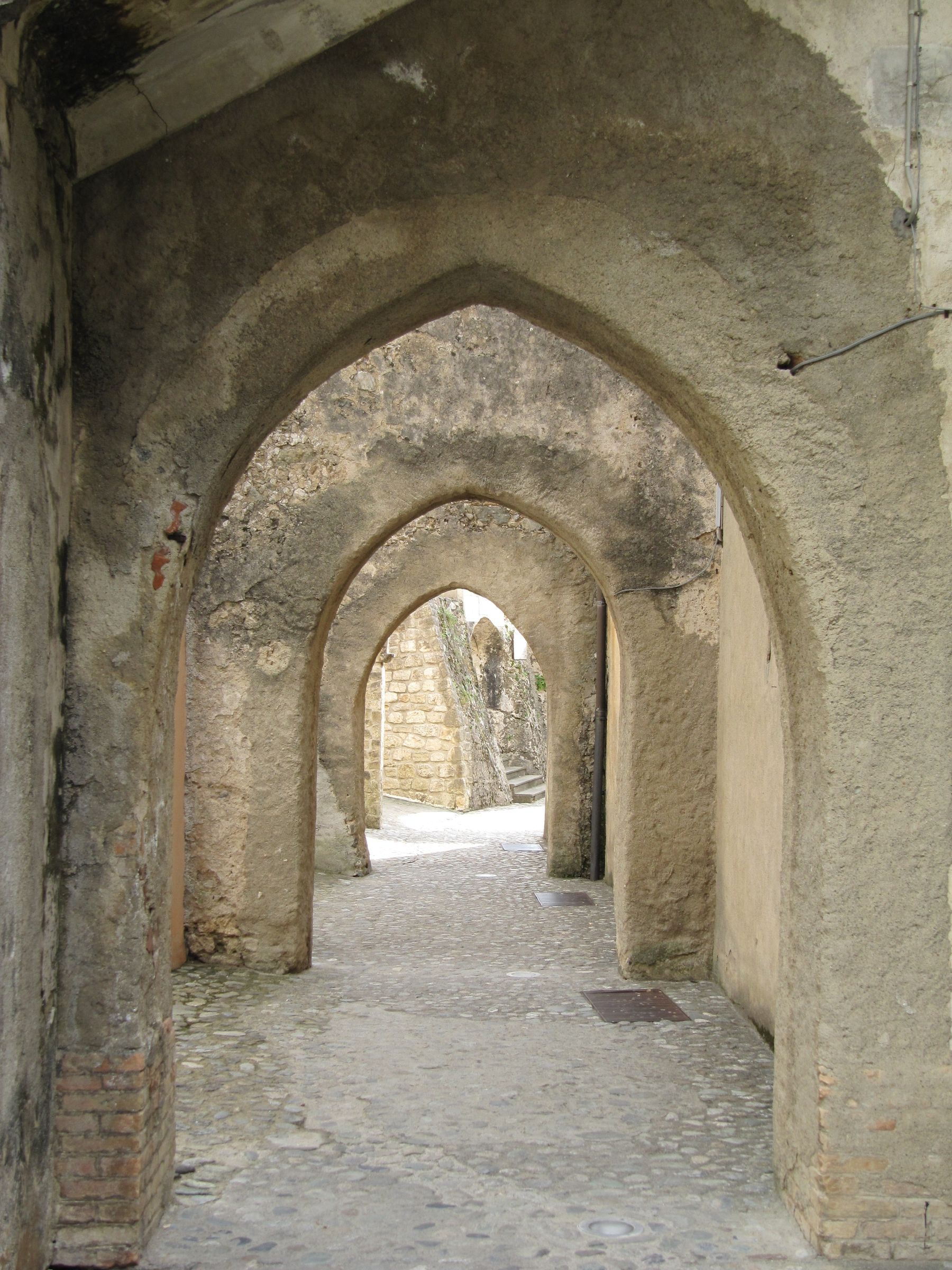 A stone arch passage opening onto daylight