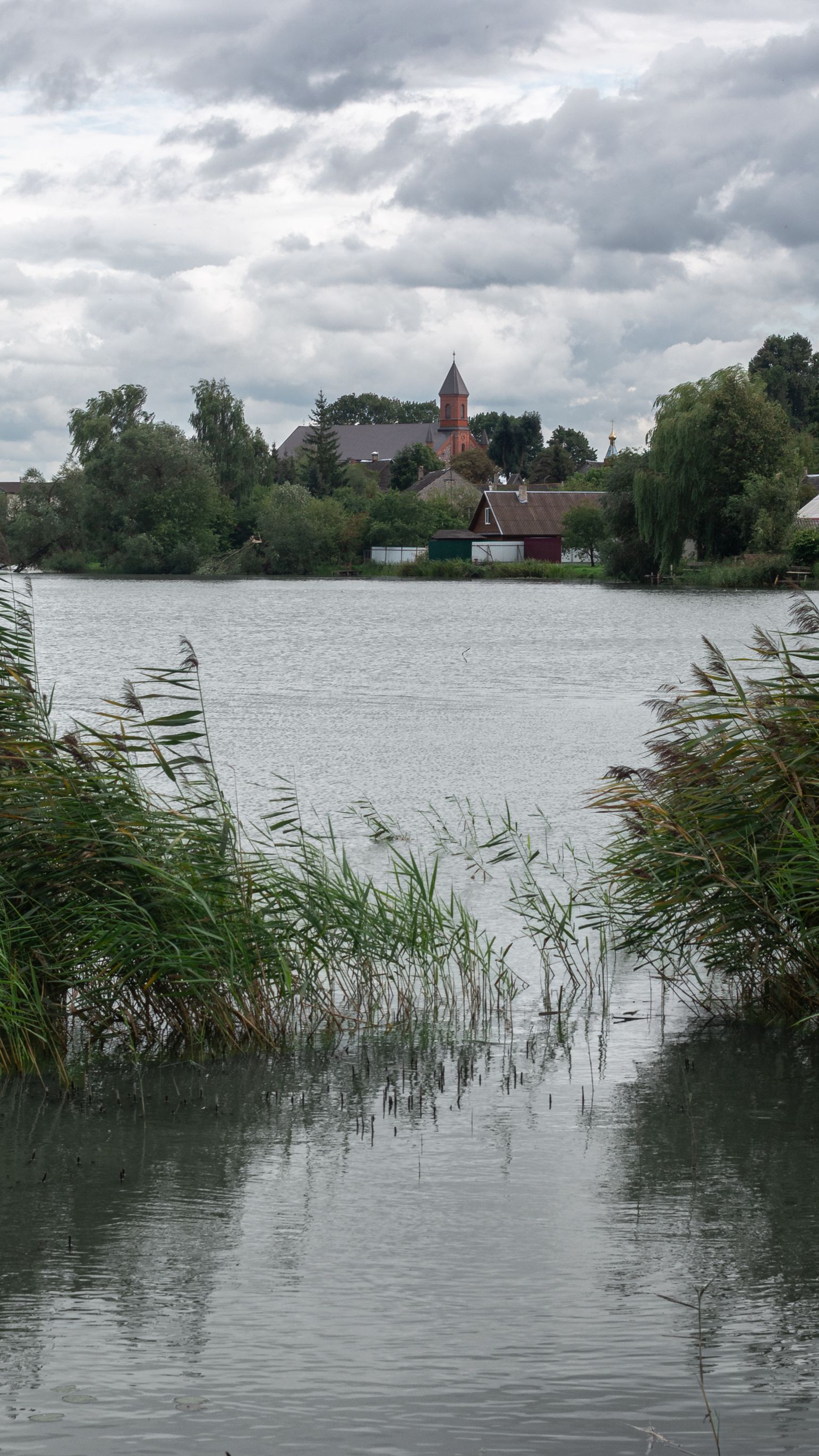 Peaceful lake scene with a distant church in Braslav, Belarus.
