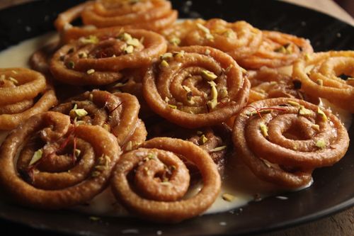 Free Delicious Indian jalebi dessert topped with pistachios in a rich, sweet syrup. Stock Photo