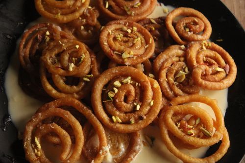 Free Close-up of juicy Indian jalebi drizzled with syrup, garnished with nuts. Stock Photo