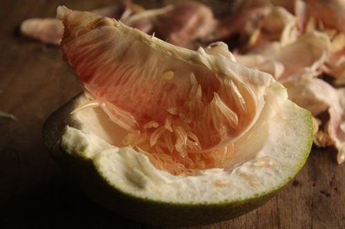 Free Detailed view of a peeled pomelo revealing its juicy interior resting on a wooden table. Stock Photo