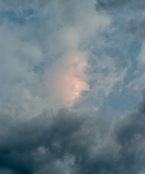 Free Moody sky with dramatic clouds illuminated by a warm sunset glow. Stock Photo