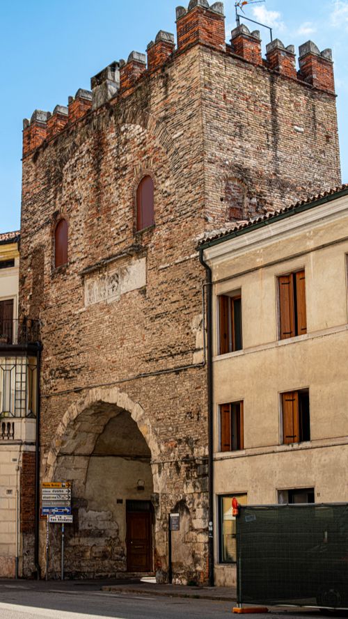 Free View of a historic brick tower in an Italian old town with clear daytime sky. Stock Photo