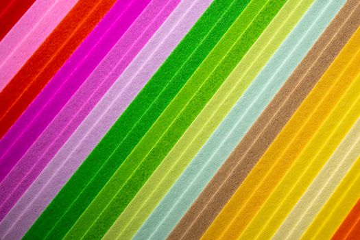 Vibrant abstract design with diagonal multicolored stripes on paper texture.