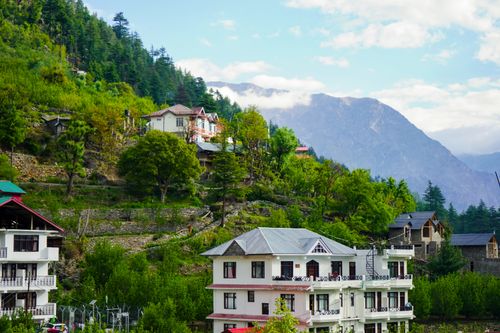 Free Picturesque mountain village with lush greenery and scenic view of the Himalayas in the background. Stock Photo