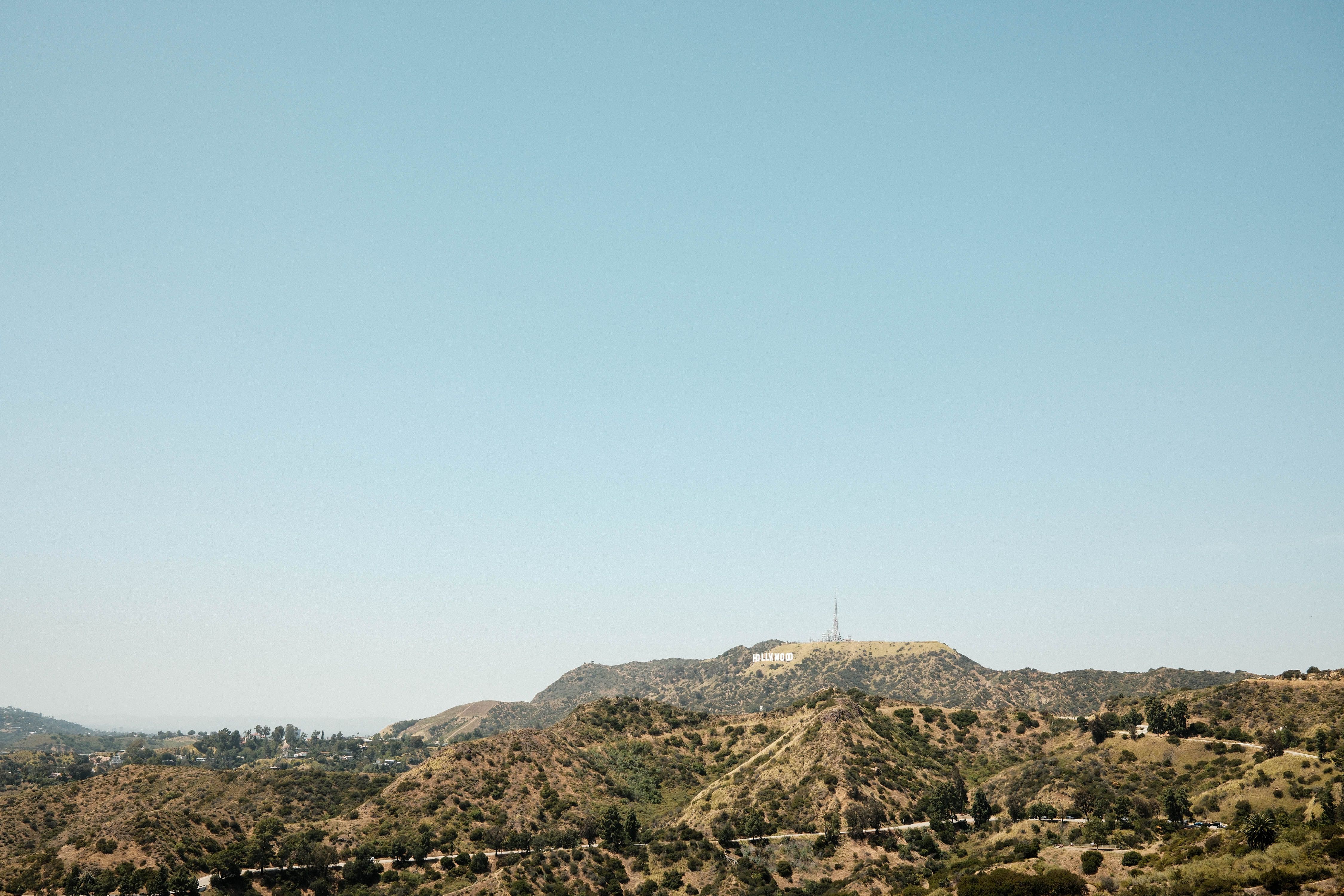 The iconic Hollywood sign perched atop the hills in Los Angeles, California under a clear blue sky.