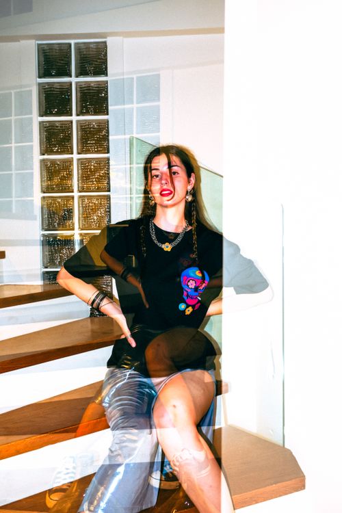 Free Artistic double exposure of a woman sitting on stairs indoors, creating a modern and edgy effect. Stock Photo