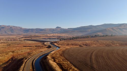 Free Aerial image of a winding road and fields in the Drakensberg mountains, KZN, South Africa. Stock Photo