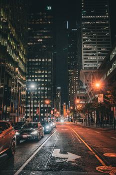 Explore the vibrant streets of downtown Toronto at night, showcasing towering skyscrapers and urban lights.