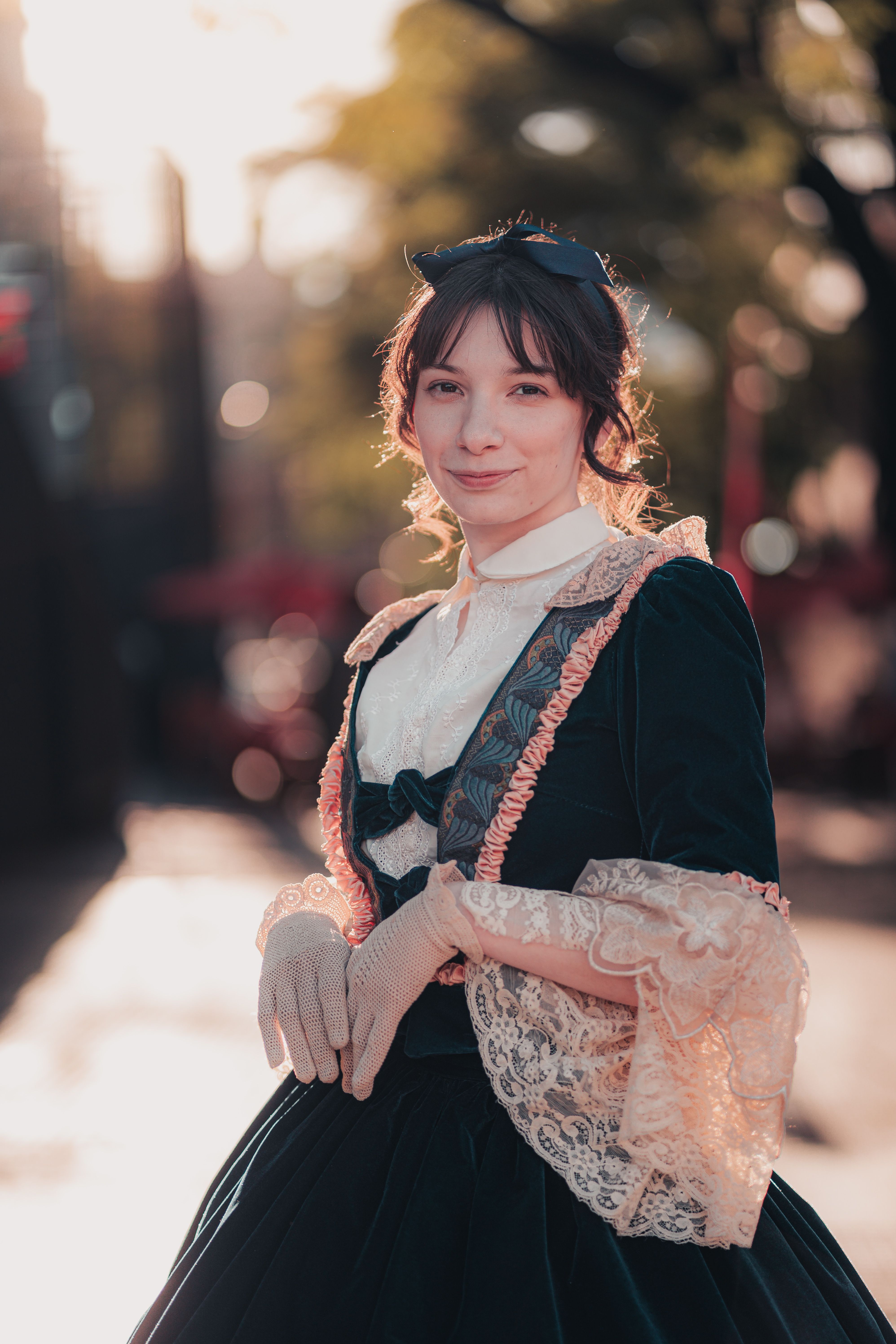 A woman in Victorian attire poses outdoors in Buenos Aires during a warm day.