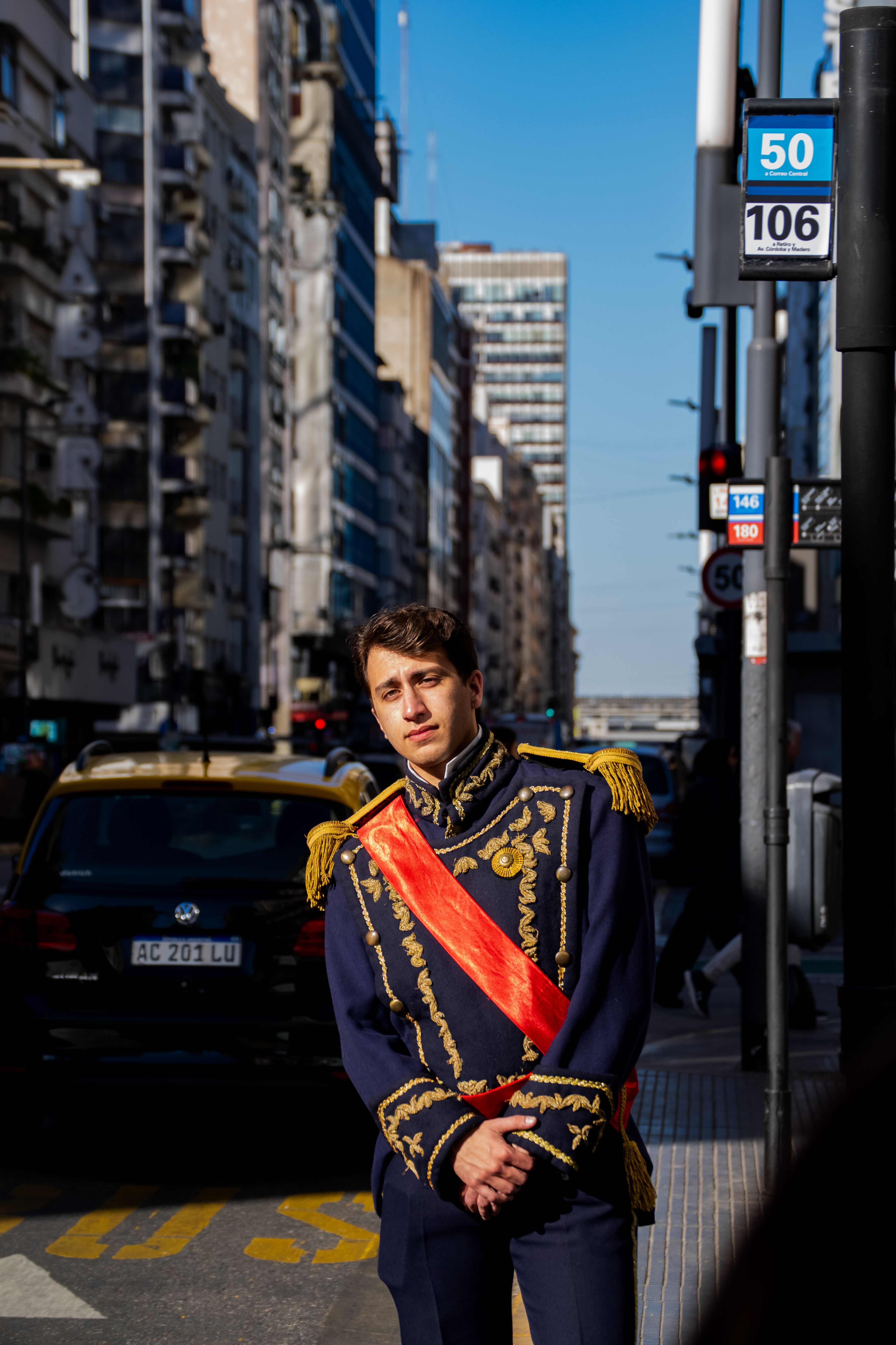 Man in historical military uniform on a bustling Buenos Aires street.