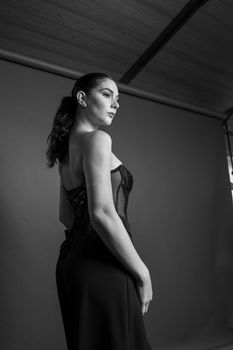 Black and white portrait of a woman in an elegant dress, side profile.
