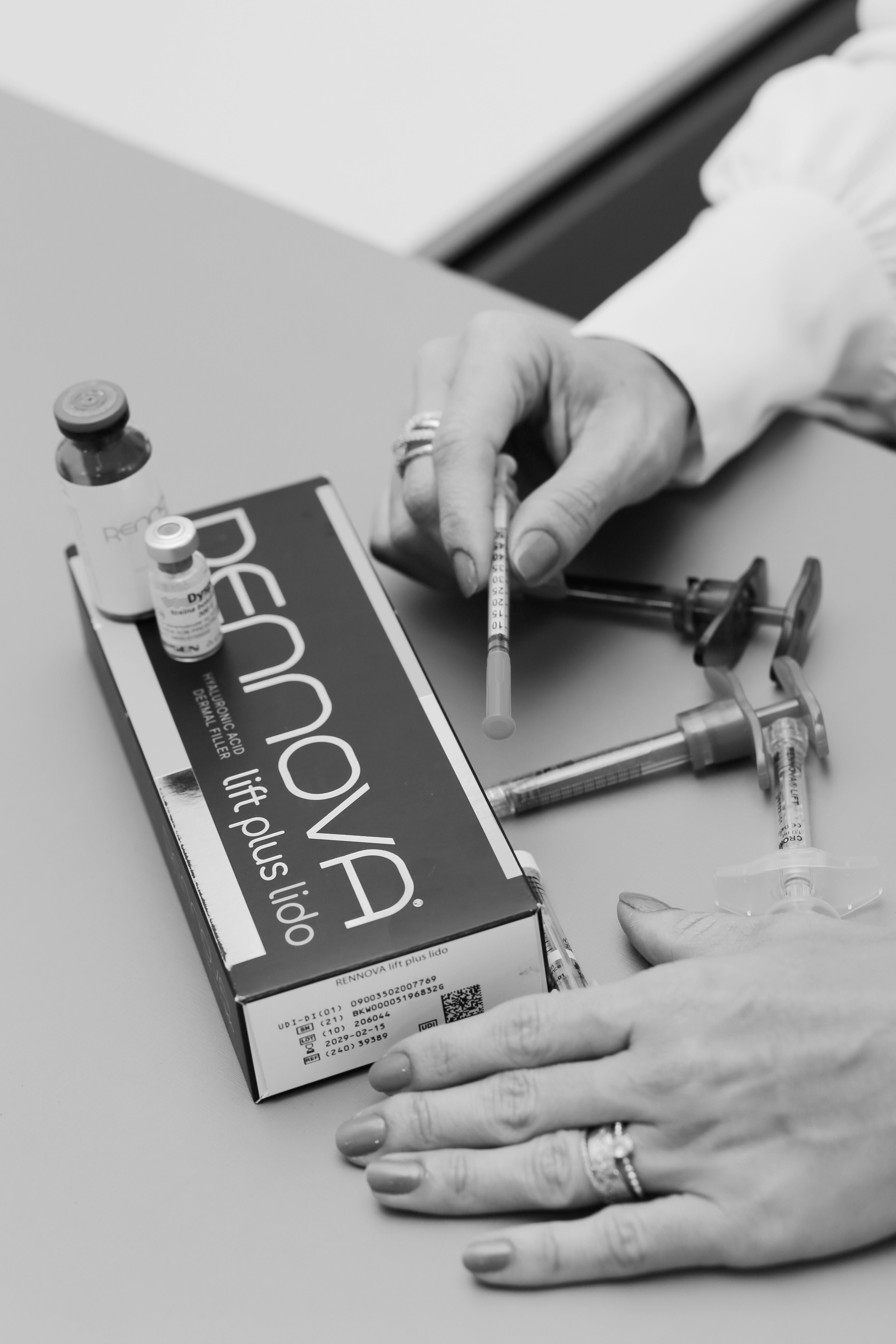 Detailed view of cosmetic injection preparation with syringes and packaging.