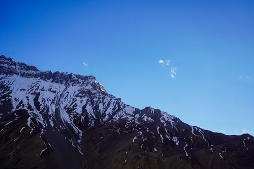 Free Breathtaking view of a snow-capped mountain against a vibrant blue sky, showcasing nature's beauty. Stock Photo