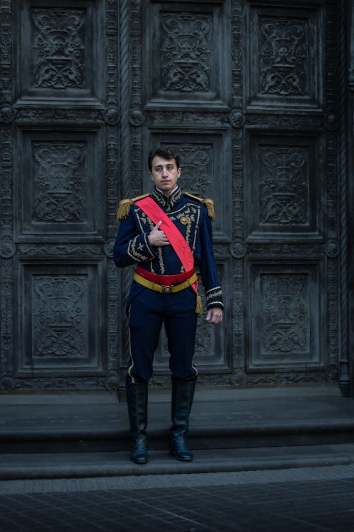 Free Man in traditional military attire stands before ornate door in Buenos Aires. Stock Photo