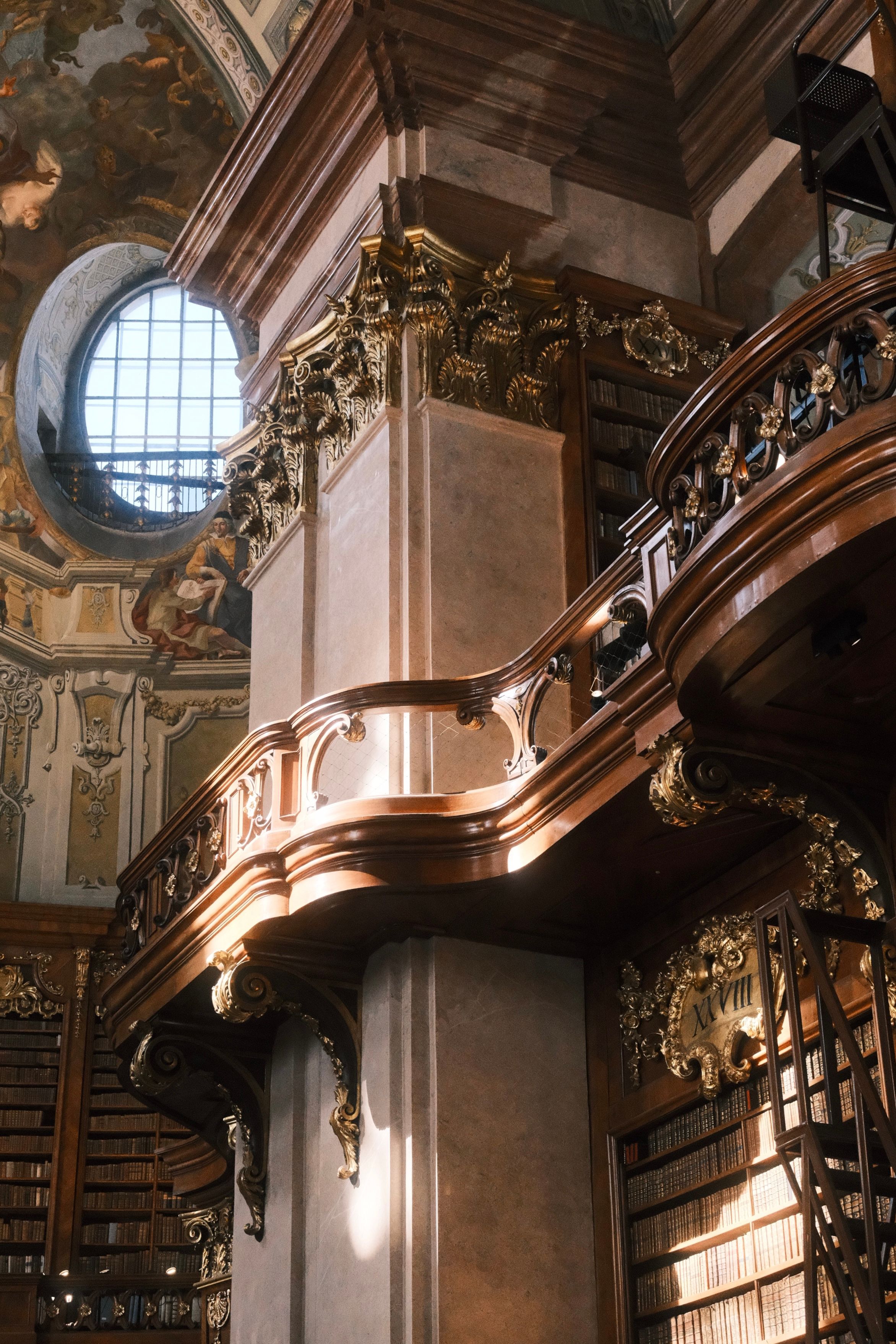 Sunlight illuminates the baroque architecture and bookshelves inside the Austrian National Library in Vienna.