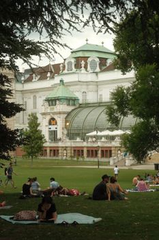 Relaxing summer day in a Vienna park with stunning historic architecture in the backdrop.