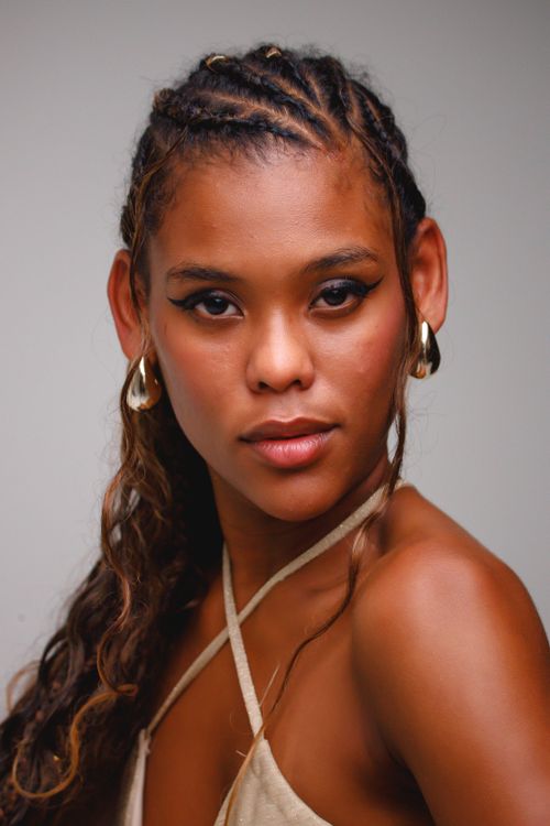 Free Elegant portrait of a young woman with braided hair and striking makeup, exuding confidence. Stock Photo