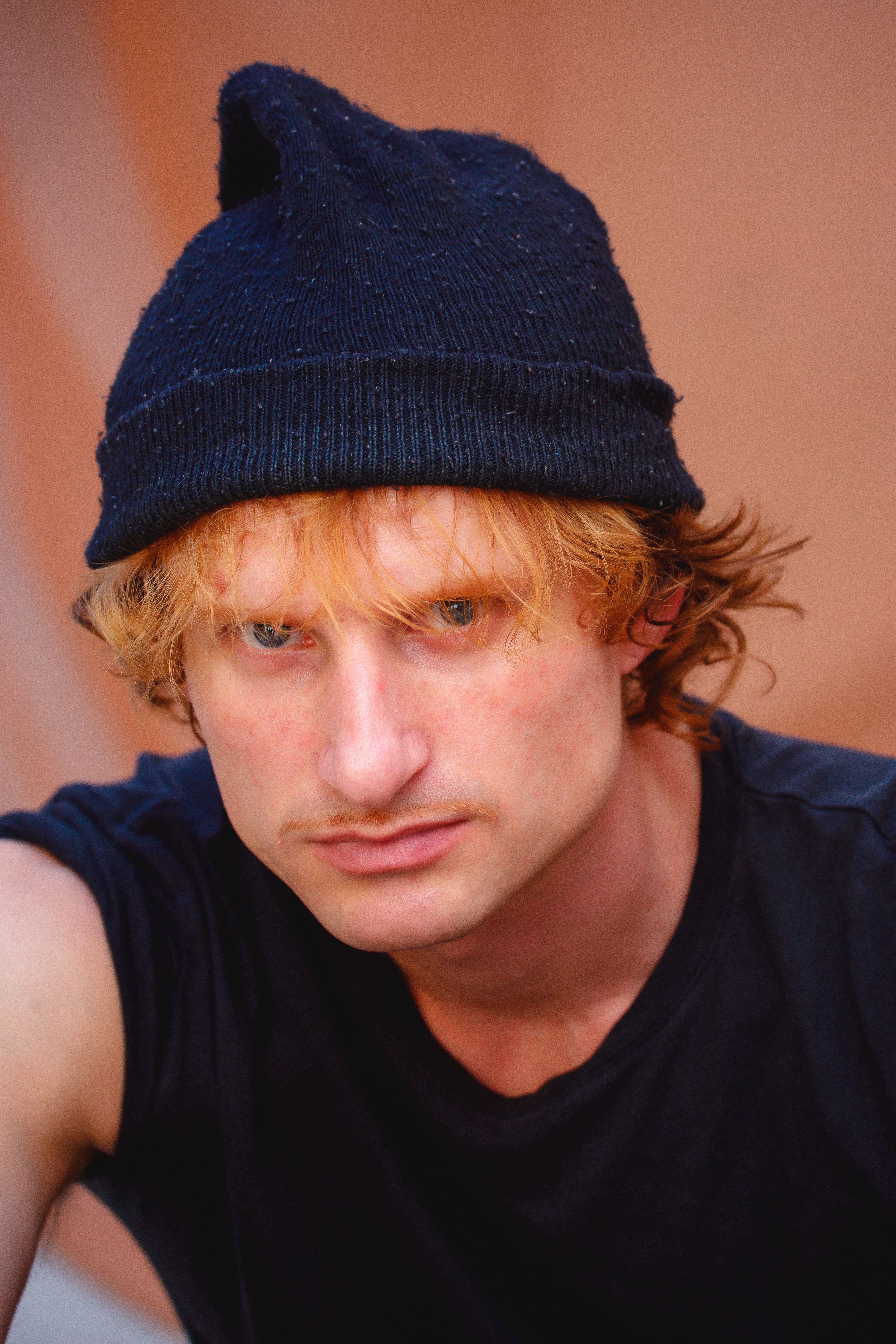 Close-up portrait of a man wearing a black beanie, showcasing a thoughtful expression.