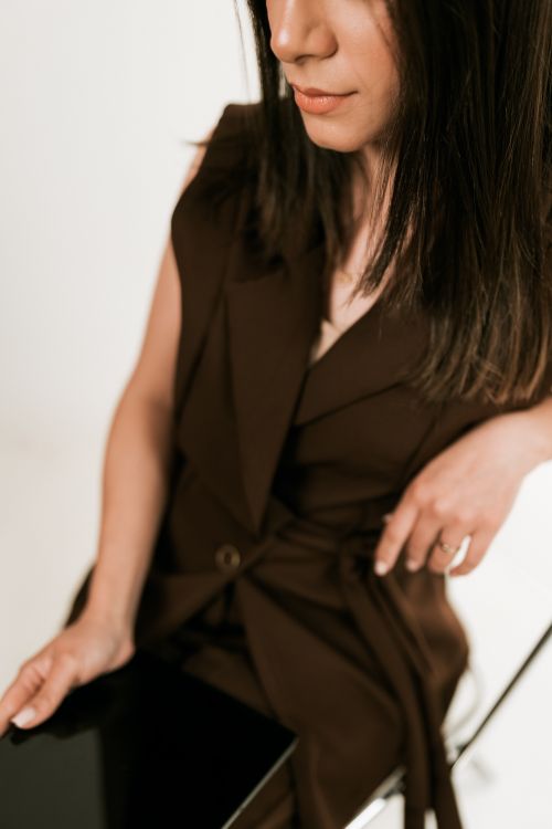 Free Elegant young woman wearing a brown outfit seated, showcasing modern fashion and style. Stock Photo