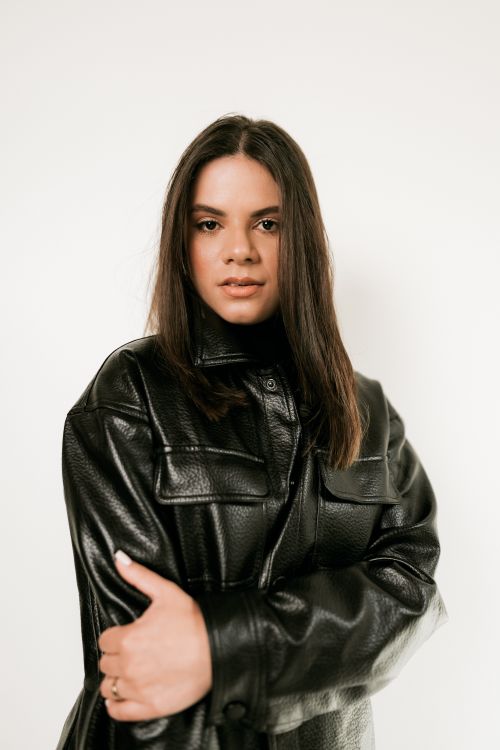 Free Portrait of a fashionable woman wearing a black leather jacket against a white background. Stock Photo