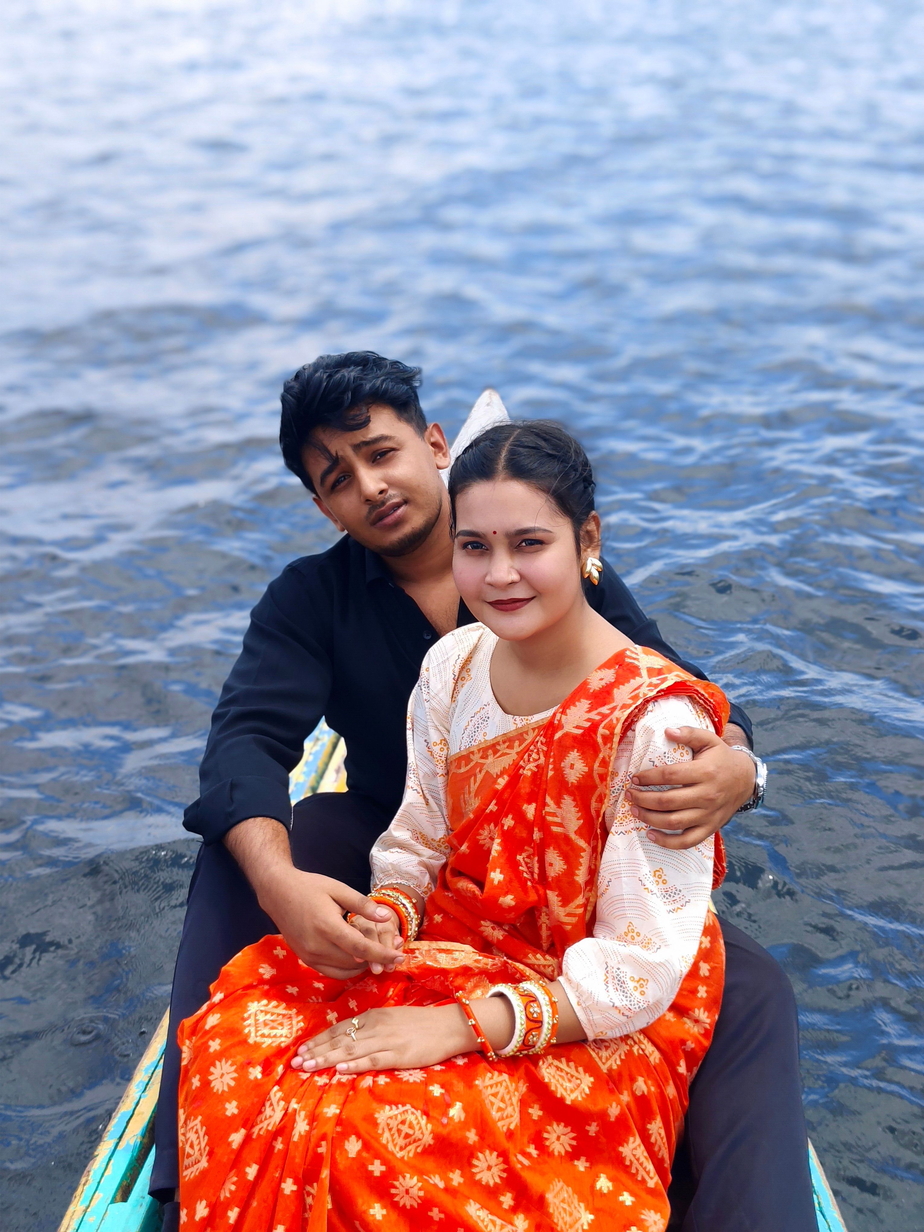 A couple enjoys a peaceful boat ride on a serene lake, highlighting romance and cultural style.