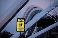 黄昏时分，人行标志与引人注目的现代建筑相映成趣，凸显了城市设计的巧思