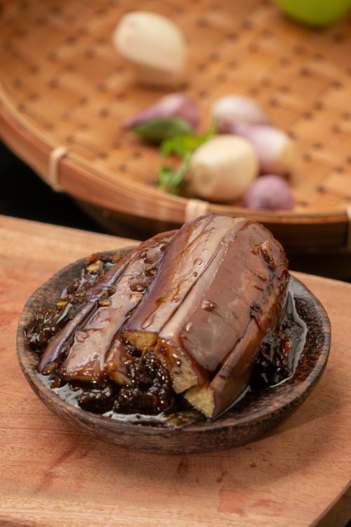 Free Tasty Indonesian eggplant dish served indoors with spices on a wooden plate. Stock Photo