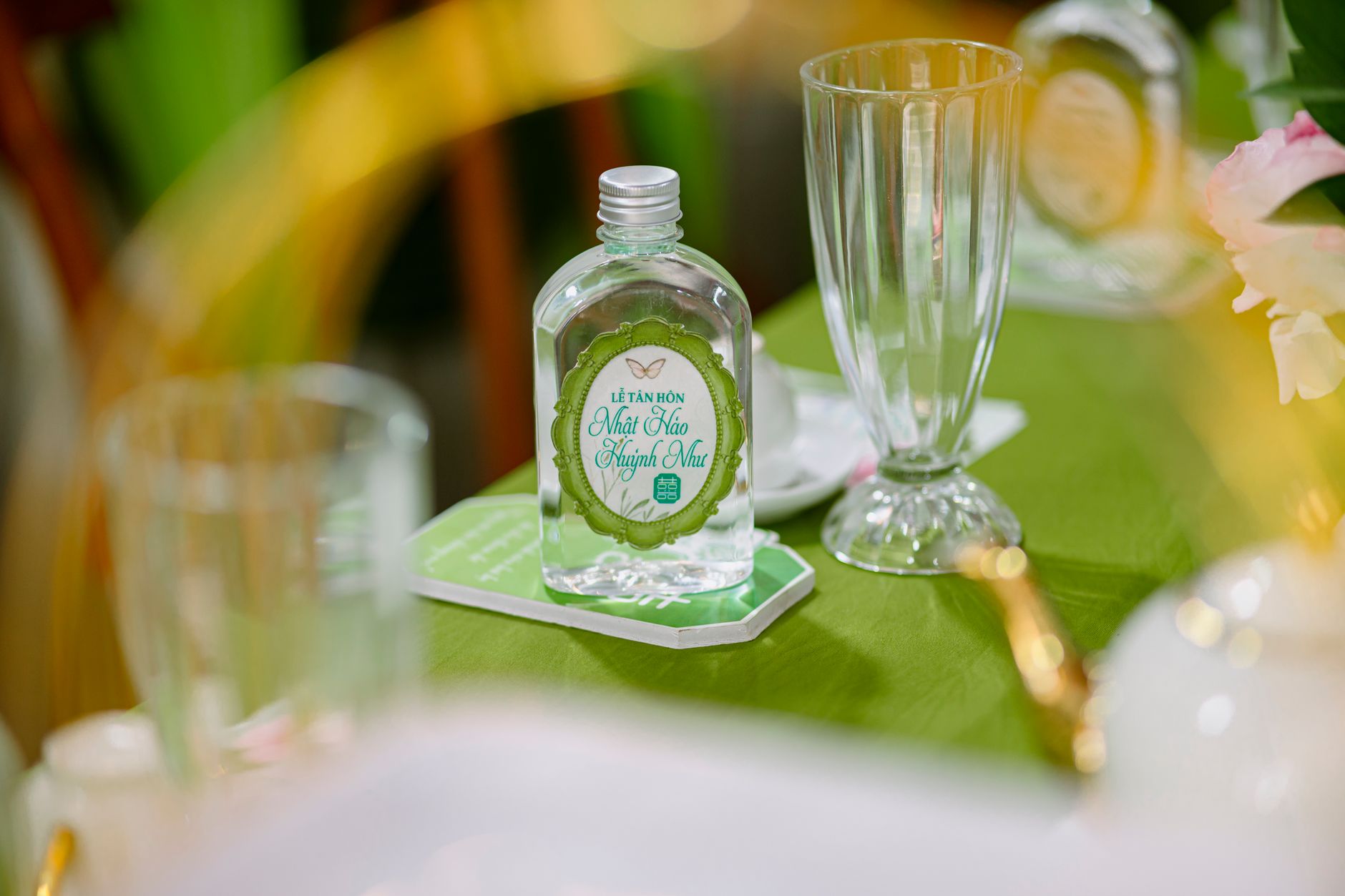 Close-up of a glass bottle on a wedding table, highlighting elegant and fresh decor.