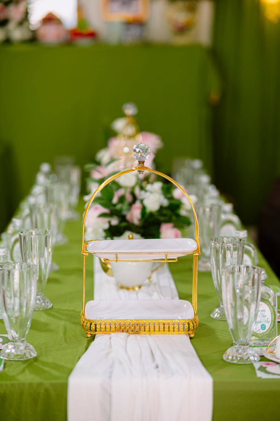 Elegant gold serving piece and glassware arranged on a wedding table