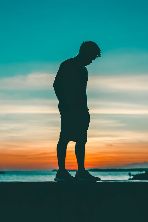 Free Tranquil silhouette of a man against a vibrant sunset sky in Iloilo City. Stock Photo