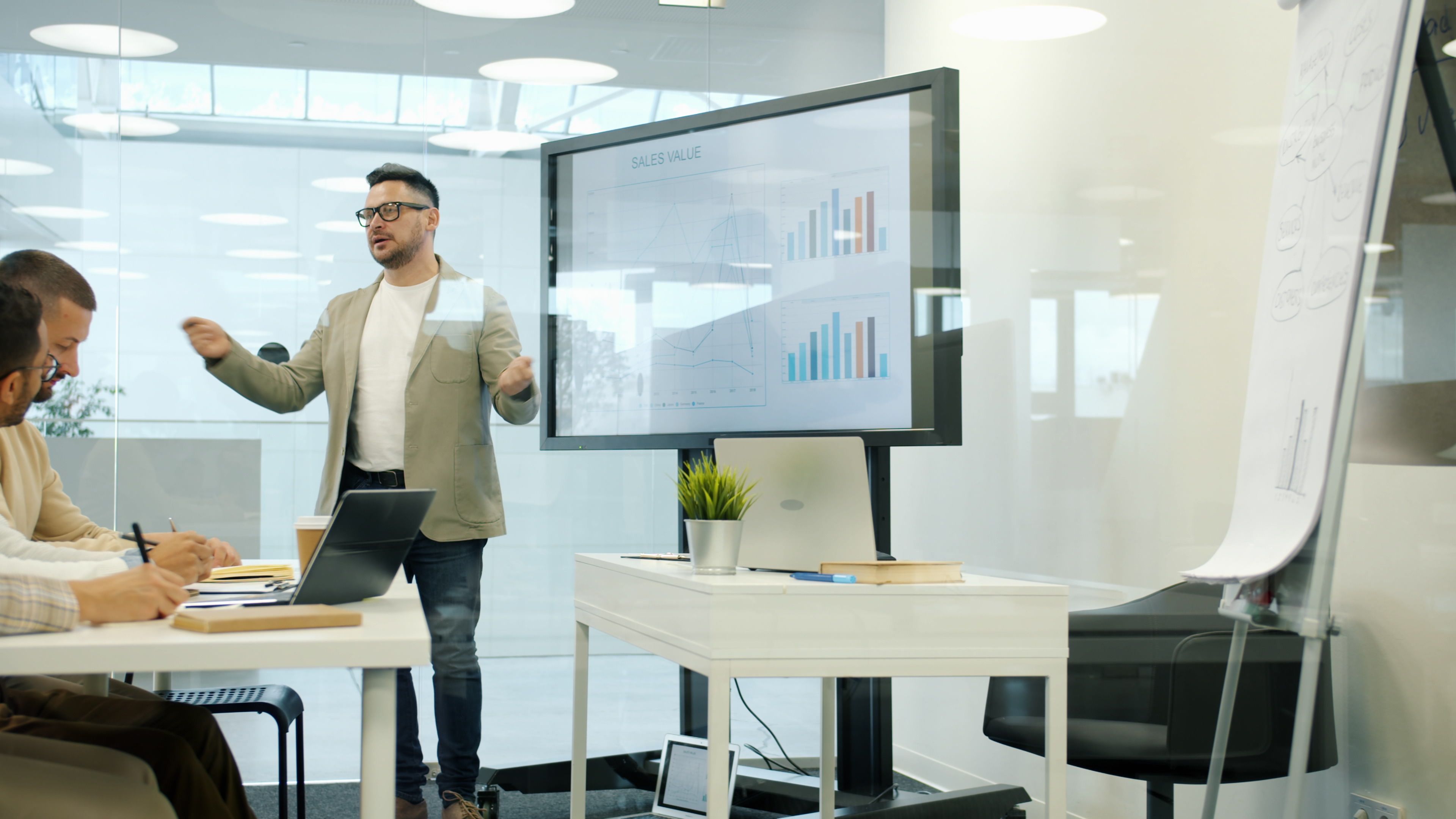 Professional presenting sales data in modern office meeting.