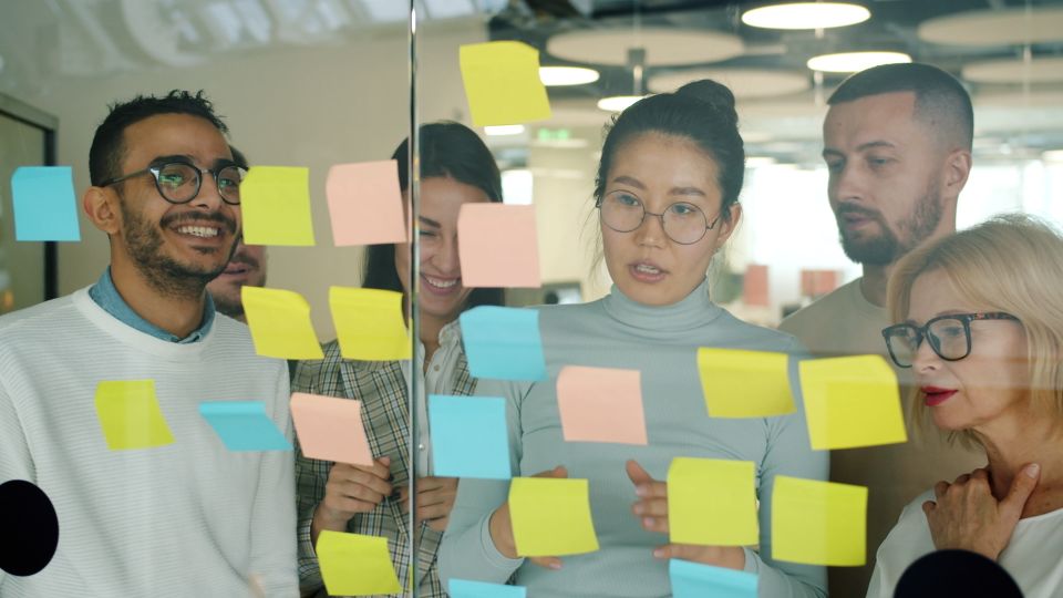 Team mapping ideas on sticky notes on a glass wall