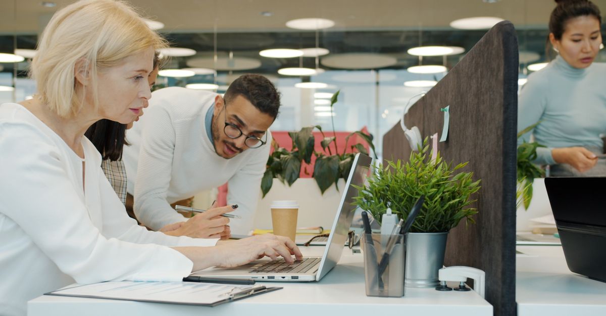 Grupo de profesionales de diversos perfiles colaborando en un espacio de trabajo de oficina moderno.