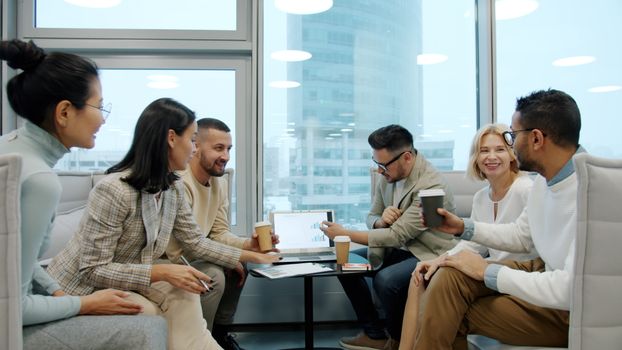 Group of professionals discussing work at a meeting table indoors.