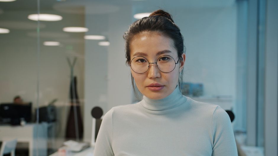 Retrato de una mujer profesional en un entorno de oficina moderno.
