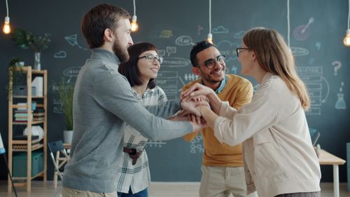 Free Four diverse adults collaborating in a creative office space. Stock Photo