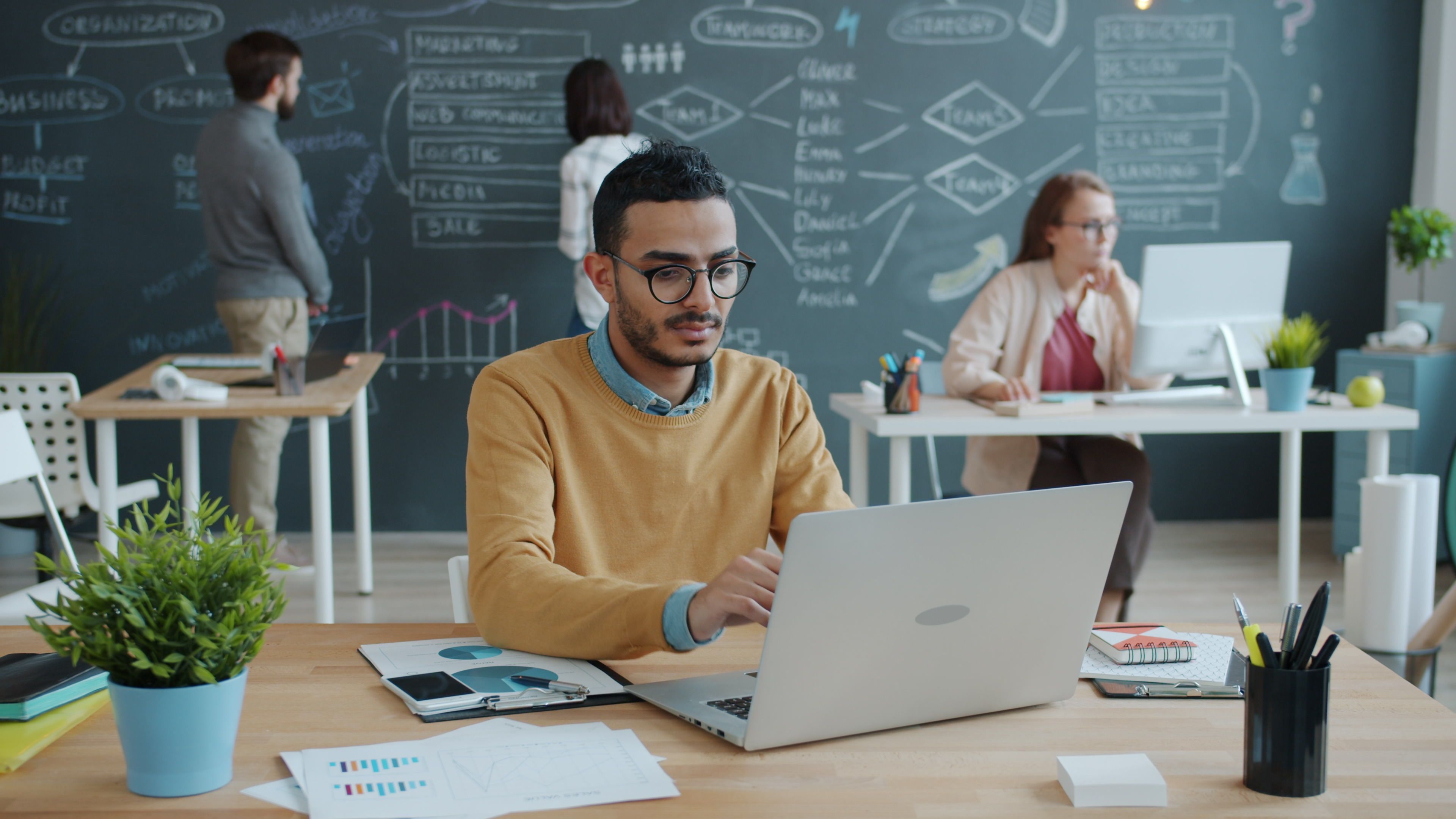 Équipe qui échange des idées de lead magnet devant un tableau dans un bureau lumineux