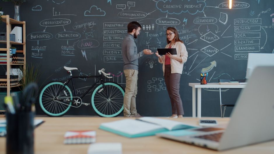 Creative brainstorming session with two professionals discussing ideas in a modern office.