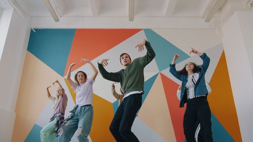 Free Energetic group of diverse people dancing indoors, showcasing modern dance moves. Stock Photo