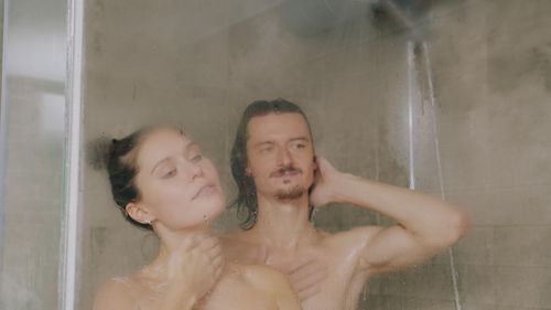 Free A serene image of a couple enjoying a relaxing moment in a steam-filled shower. Stock Photo