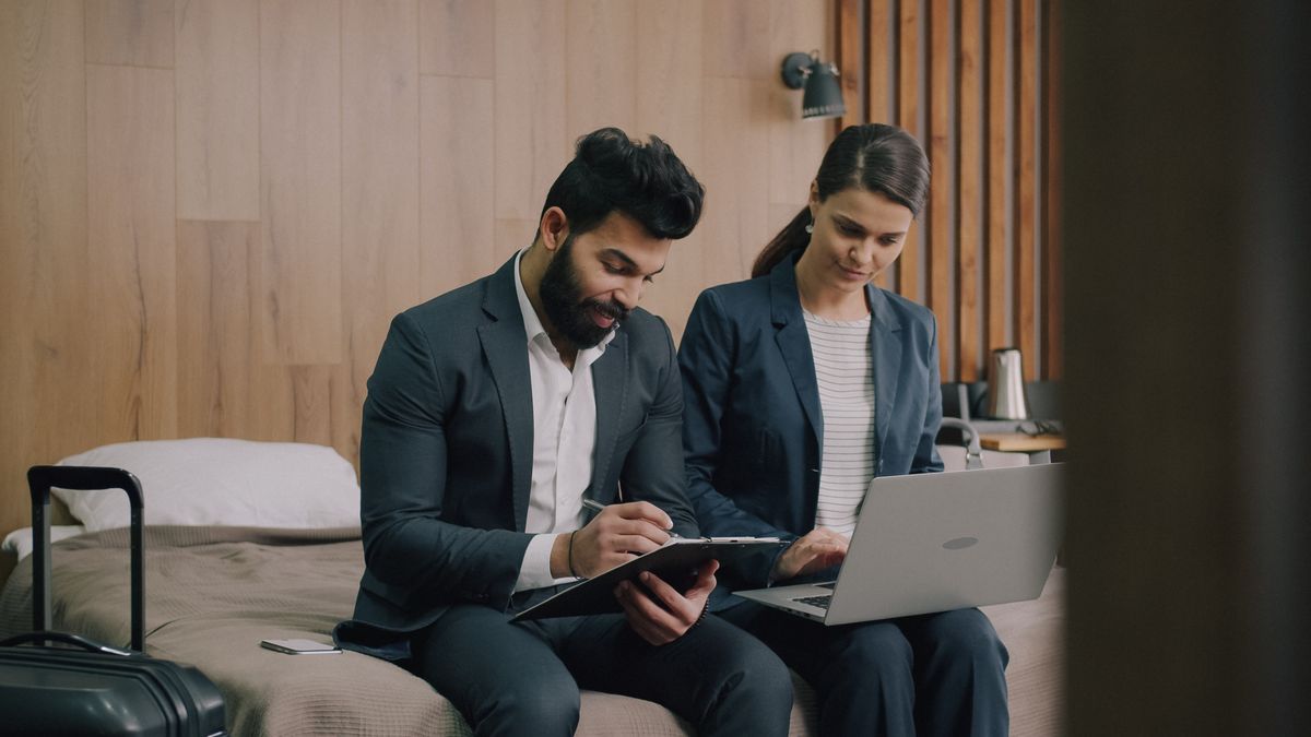 Colleagues working on a laptop in a hotel room