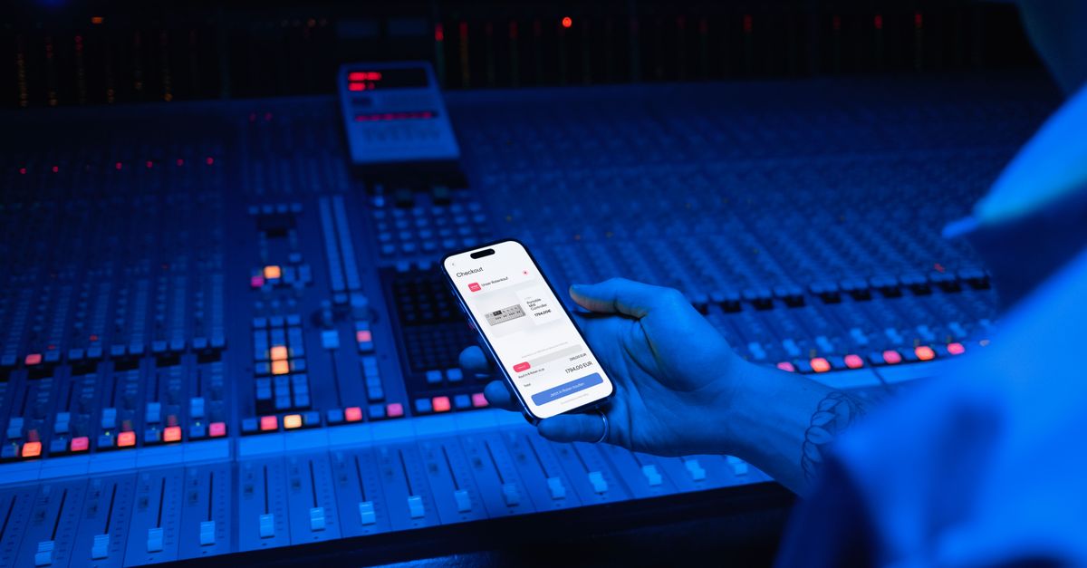 A smartphone displaying digital payment in a modern music studio setting.