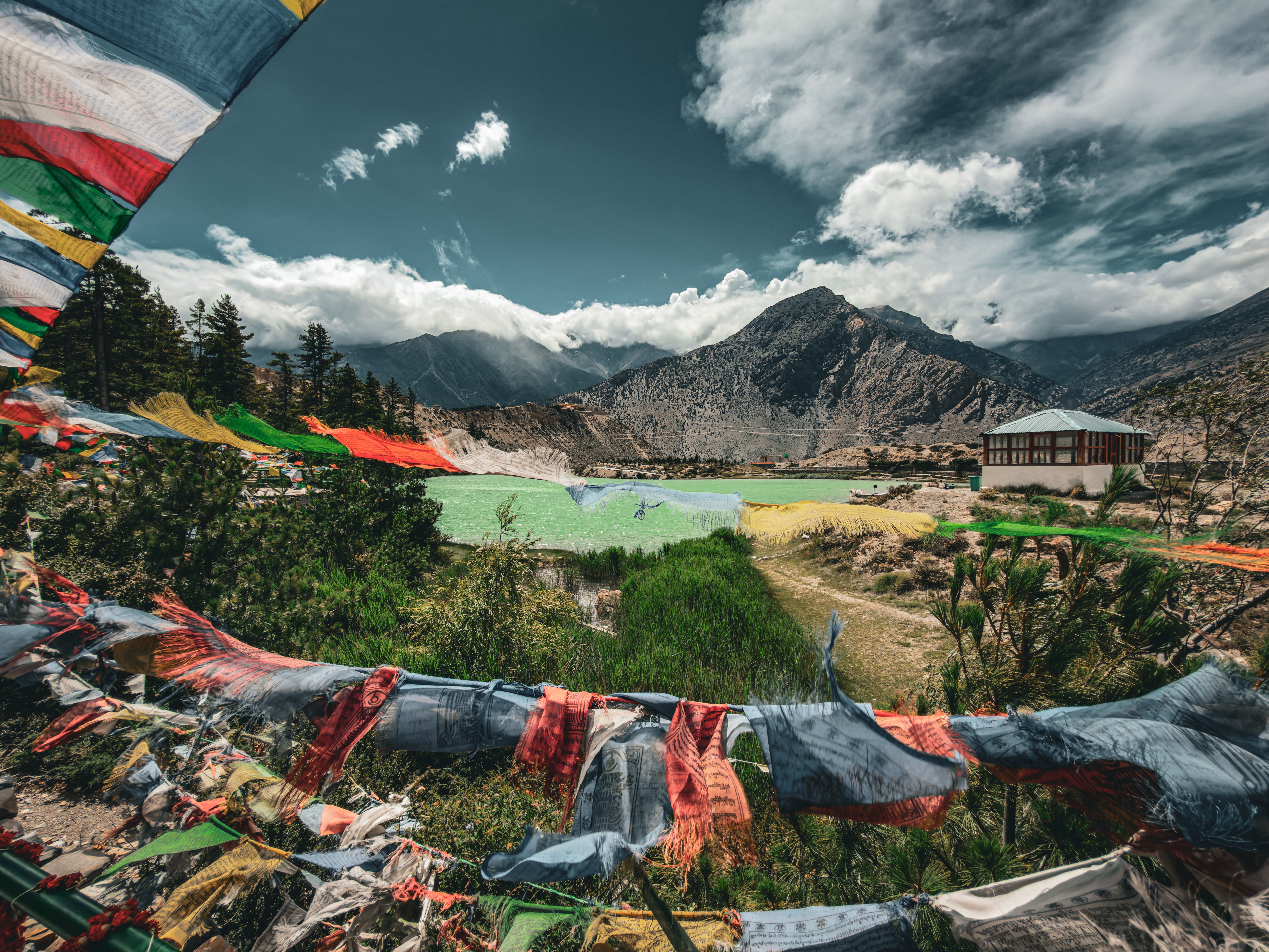Prayer flags strung across a ridge at Jomsom in Nepal, mountains behind