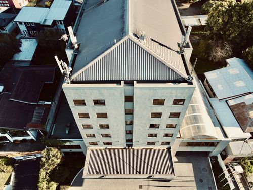 Free A top-down aerial view of a modern urban building with a corrugated metal roof. Stock Photo