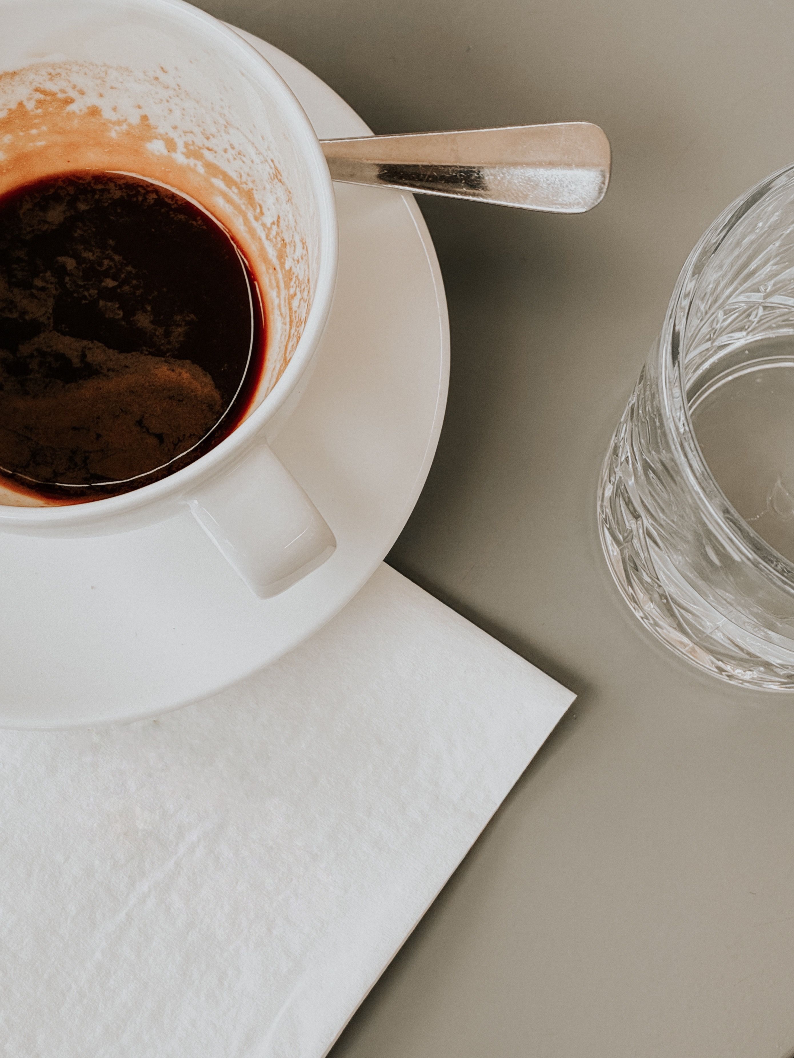 Top view of an empty espresso cup and glass on a napkin, minimalist aesthetic in Vienna.