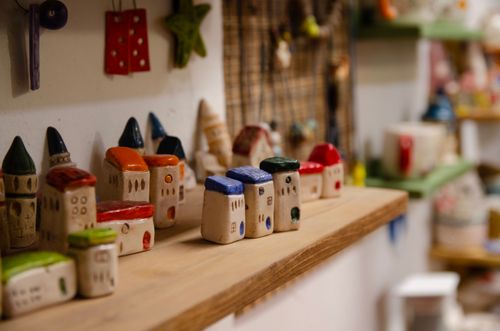 Free Charming collection of colorful ceramic house miniatures on a shelf in an artisan shop. Stock Photo