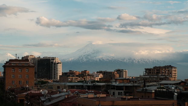 Discover a stunning view of snowy Mount Ararat rising above Yerevan's urban landscape.