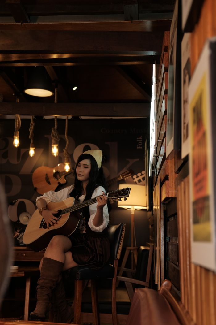 A singer with an acoustic guitar in a warmly lit room
